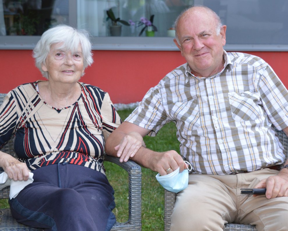 Eine Bewohnerin und ein Bewohner sitzen nebeneinander.